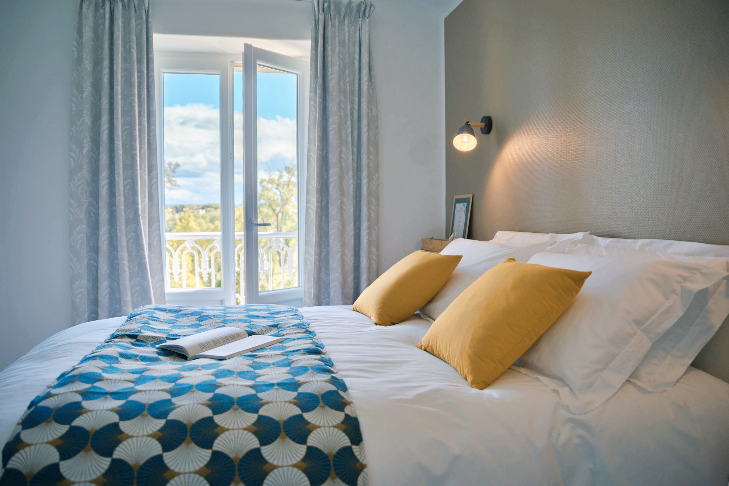 Chambre Capucine lumineuse, équipée d’une porte-fenêtre qui remplace la fenêtre traditionnelle, offrant une belle vue sur l’extérieur donnant sur le parc du château et une luminosité naturelle abondante.