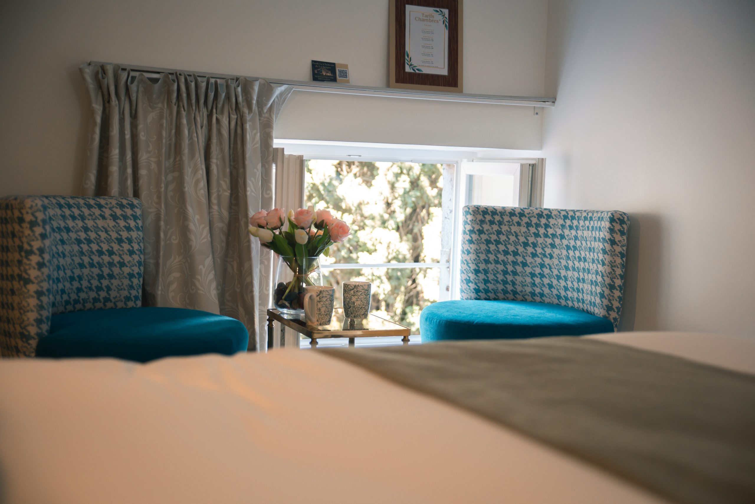 Coin détente aménagé dans la chambre Églantine, avec fauteuil confortable et ambiance douce, parfait pour lire, se reposer ou savourer un moment de calme.