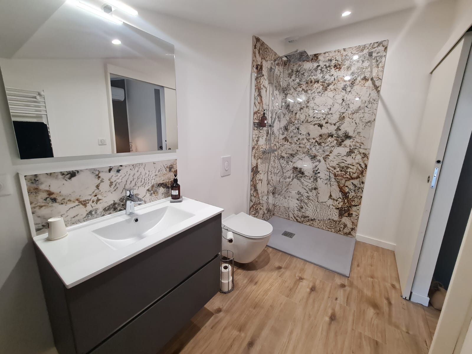 Salle de bain raffinée alliant design contemporain et équipements pratiques, offrant un espace détente chaleureux.