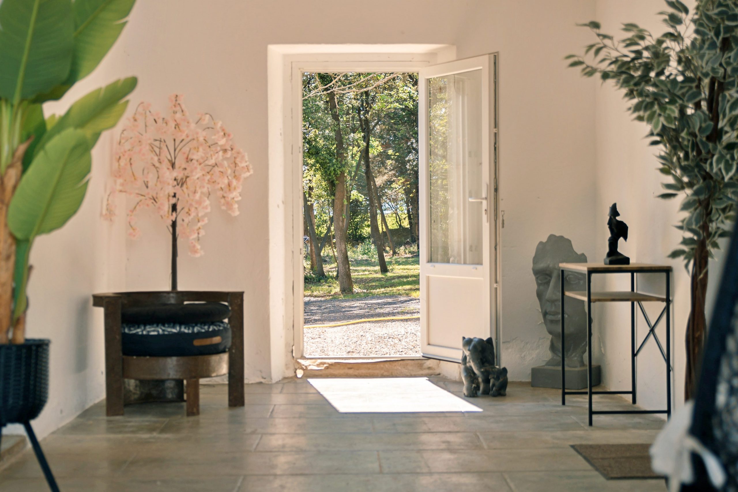 Sas frais et accueillant, parfait pour lire un livre en toute tranquillité, avec accès à une salle de détente enrichie de livres, au cabinet d’Agnès, notre énergéticienne à domicile, et à une entrée directe sur le parc verdoyant.